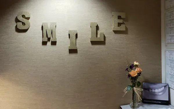 Wooden letters spelling SMILE on the wall at Cooley Smiles.